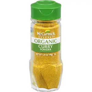 McCormick Gourmet Organic Curry Powder jar on a kitchen counter with Indian spices