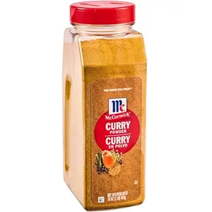 Large 16 oz McCormick Curry Powder container next to a bowl of curry