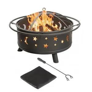 Round black steel fire pit with star and moon cutouts, spark screen, and poker on grass