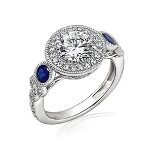 Vintage style platinum-plated ring with clear cubic zirconia center and blue sapphire accents
