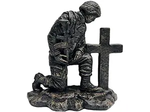 Kneeling soldier praying at a cross concrete memorial statue
