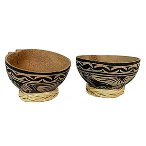 Two hand-carved jicaras with natural fiber bases on a rustic table