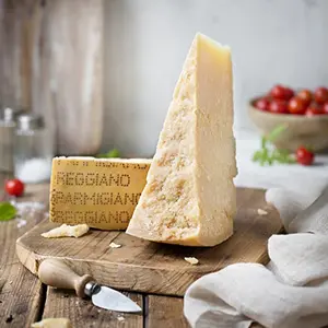 Wedge of aged Parmigiano Reggiano DOP 24 months on wooden board