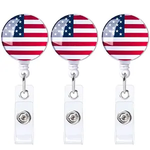 Set of three PAGOW American flag badge reels with alligator clips on white background