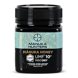 Manuka Hunters UMF 10+ honey jar with a spoonful of honey being drizzled over oatmeal