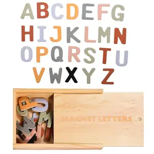 CHILDLIKE BEHAVIOR wooden alphabet magnets with neutral colors on a fridge