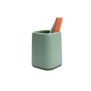 Green rectangular pencil cup on a desk