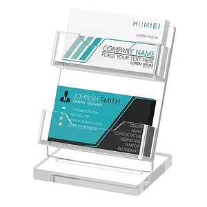 Two-tier clear acrylic business card holder filled with business cards, side view