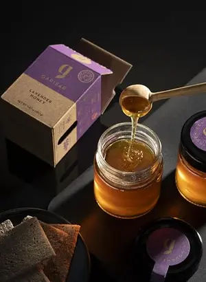 Garisar Premium Single Location Lavender Honey jar on a rustic table with lavender sprigs