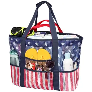 American flag mesh beach bag with multiple compartments on sandy beach