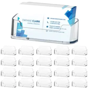 Twenty small clear acrylic card holders stacked together on a white surface