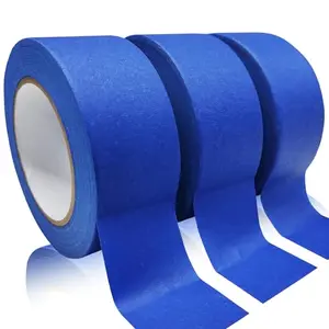 Wide blue painter's tape being applied to a wall