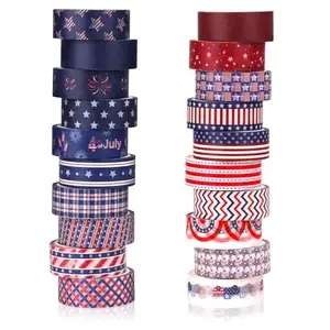 Twenty rolls of washi tape with various red, white, and blue patterns on a pink mat