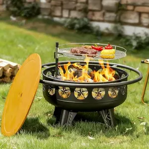 Round black metal fire pit with star cutouts, cooking grate, and lid on a deck