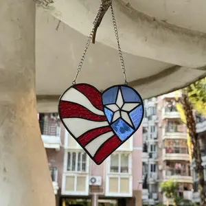 Handcrafted American flag heart stained glass suncatcher hanging in a window