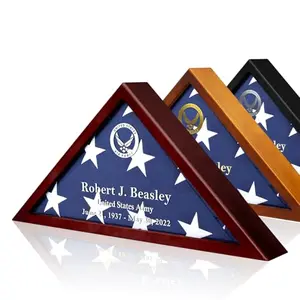 Brown customized flag display case with metal nameplate and emblem, displaying a folded burial flag on a wall.