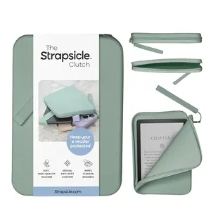Strapsicle sage green silicone clutch holding a Kindle and phone, showing soft texture and dust-free surface
