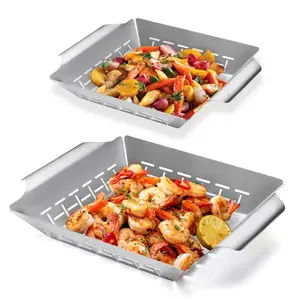 Two rectangular stainless steel grill baskets on a grill, filled with vegetables