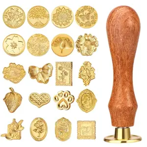 Draupnir wax seal stamp kit with 21 gold-colored heads and wooden handle on a vintage letter