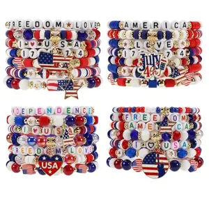 Bulk set of 28 red, white, and blue beaded bracelets with star and heart charms, arranged on a table