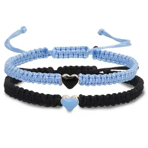 Black and blue cord couple bracelets with heart charms on a white background