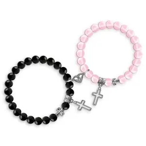 Christian couple bracelets with black and pink cords on a gift box