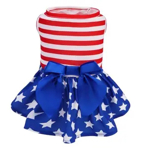 Small dog in red-white-blue star dress with bowtie sitting by Thanksgiving pie