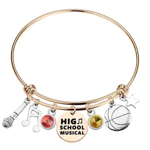 Gold tone musical charm bracelet with adjustable wire bangle and star motifs