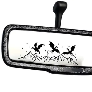 Black silhouette decal of dragon flying over mountains against a white background