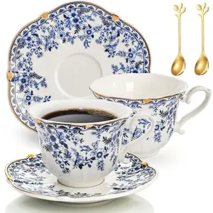 Two blue willow patterned teacups with saucers and spoons on a table