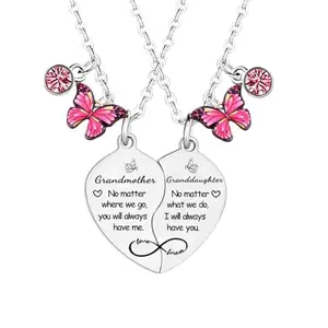 Two butterfly-shaped pendants on chains, one larger engraved 'Grandmother' and one smaller 'Granddaughter'