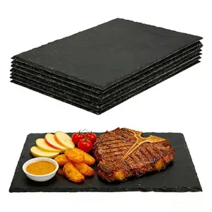 Stack of eight black slate cheese boards with chalk