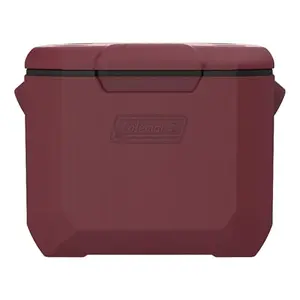 Cranberry red Coleman 60-quart wheeled cooler with retractable handle on a grassy field